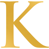 Gold serif letter K, the Korbel monogram, on a plain background