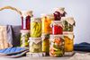 a variety of pickled fruits and vegetables in jars, arranged in a beautiful and tasteful way for sandwiches