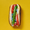 A Chicago hot dog from above on a yellow background: an all-beef frank on a poppy-seed bun with tomato wedges, a whole sport pepper, onion and relish.