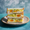 A Japanese tamago sando: jammy soft-boiled egg and egg salad between crustless white shokupan, dusted with dill, stacked on a ceramic plate.