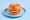 A thick slab of pink Leberkäse in a sesame kaiser roll, on a pale blue plate against a blue background.