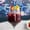 A glass of red sangria with a fruit skewer on a marble table, blue leopard-print wallpaper behind