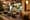 Cafe interior: bentwood chairs, stone tables, a painted garden mural and a hanging BAKERY sign