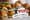Stacked croissant sandwiches with toothpicks, with the Pop's Deli & Grill logo overlaid