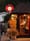 Black-painted tap room at dusk, round red Tap Room sign above a red-framed window with diners inside