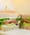 A wheat-bread sandwich cut in half, layered with sprouts, tomato, avocado and lettuce, toothpick on top
