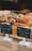 Bakery display case with croissants and crumb muffins behind small chalkboard price signs