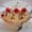 Banana split with whipped cream, chocolate drizzle and three maraschino cherries on a plate with a doily