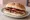Bacon and Sausage Butty: an illustration of bacon, sausage, butter, brown sauce and more.