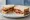 Bacon Butty: an illustration of bacon, butter, brown sauce and ketchup on white bread.