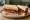 Bacon Sarnie: an illustration of bacon, butter, brown sauce and ketchup on white bread.