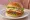 Balık Burger: an illustration of fish, lettuce, tomato and onion on burger bun.