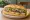 Balık Ekmek: an illustration of onion, lettuce and lemon on bread.