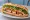 Bánh Mì Ba Chỉ Quay: an illustration of pork belly, đồ chua, cilantro, cucumber and more on bánh mì baguette.