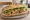 Bánh Mì Berlin: an illustration of pork, mayonnaise, đồ chua, cucumber and more on bánh mì baguette.