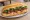 Bánh Mì Bò Lúc Lắc: an illustration of beef, mayonnaise, đồ chua, cucumber and more on bánh mì baguette.