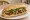 Bánh Mì Bò Xào Hành Tây: an illustration of beef, onion, mayonnaise, đồ chua and more on bánh mì baguette.