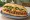 Bánh Mì Bò Xào Sả Ớt: an illustration of beef, lemongrass, pepper, mayonnaise and more on bánh mì baguette.