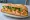 Bánh Mì Cá Chiên: an illustration of fish, mayonnaise, đồ chua, cucumber and more on bánh mì baguette.