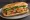 Bánh Mì Chả Giò: an illustration of pork, đồ chua, cucumber, cilantro and more on bánh mì baguette.