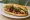 Bánh Mì Chim Cút Nướng: an illustration of đồ chua, cucumber, cilantro, pepper and more on bánh mì baguette.