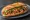 Bánh Mì Gà Nướng: an illustration of chicken, lemongrass, đồ chua, cucumber and more on bánh mì baguette.