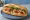 Bánh Mì Gà Rô Ti: an illustration of chicken, đồ chua, cucumber and cilantro on bánh mì baguette.