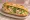 Bánh Mì Gà Xé Phay: an illustration of chicken, cabbage, lime, đồ chua and more on bánh mì baguette.