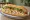 Bánh Mì Ghẹ: an illustration of crab, đồ chua, cucumber, cilantro and more on bánh mì baguette.
