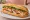 Bánh Mì Giò Chả: an illustration of pork, chả lụa, đồ chua, cucumber and more on bánh mì baguette.