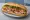 Bánh Mì Huế Đặc Biệt: an illustration of pork, chả lụa, pâté, đồ chua and more on bánh mì baguette.