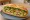 Bánh Mì Khổ Qua: an illustration of pork, egg, đồ chua, cucumber and more on bánh mì baguette.