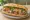 Bánh Mì Móng Giò: an illustration of pâté, đồ chua, cucumber and cilantro on bánh mì baguette.