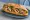 Bánh Mì Mực Xào: an illustration of squid, onion, đồ chua, cucumber and more on bánh mì baguette.