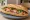 Bánh Mì Phố Cổ: an illustration of pork, pâté, đồ chua, cucumber and more on bánh mì baguette.