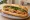 Bánh Mì Ram: an illustration of pork, đồ chua, cucumber, cilantro and more on bánh mì baguette.