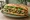 Bánh Mì Rau Xào: an illustration of garlic, đồ chua, cucumber, cilantro and more on bánh mì baguette.