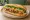 Bánh Mì Sốt: an illustration of pork, gravy, đồ chua, cucumber and more on bánh mì baguette.