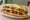 Bánh Mì Sườn Non: an illustration of pork, đồ chua, cucumber and cilantro on bánh mì baguette.