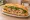 Bánh Mì Tai Heo: an illustration of pork, đồ chua, cucumber and cilantro on bánh mì baguette.