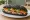 Bánh Mì Than Hoạt Tính: an illustration of pork, pâté, mayonnaise, đồ chua and more on bánh mì baguette.