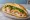 Bánh Mì Thịt Luộc Mắm Nêm: an illustration of pork, fish sauce, đồ chua, cucumber and more on bánh mì baguette.
