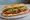 Bánh Mì Thịt Nướng BBQ: an illustration of pork, bbq sauce, đồ chua, cucumber and more on bánh mì baguette.