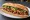 Bánh Mì Thịt Nướng Sả: an illustration of pork, lemongrass, đồ chua, cucumber and more on bánh mì baguette.