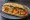 Bánh Mì Tôm Chiên: an illustration of shrimp, mayonnaise, đồ chua, cucumber and more on bánh mì baguette.
