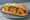 Bánh Mì Tôm Xào: an illustration of shrimp, đồ chua, cucumber and cilantro on bánh mì baguette.