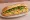 Bánh Mì Trứng Chiên Hành: an illustration of egg, onion, đồ chua, cucumber and more on bánh mì baguette.