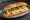 Bánh Mì Trứng Cuộn: an illustration of egg, đồ chua, cucumber and cilantro on bánh mì baguette.