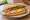 Bánh Mì Trứng Ốp La: an illustration of egg, đồ chua, cucumber, cilantro and more on bánh mì baguette.
