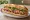 Bánh Mì Westminster: an illustration of pâté, đồ chua, cucumber, cilantro and more on bánh mì baguette.